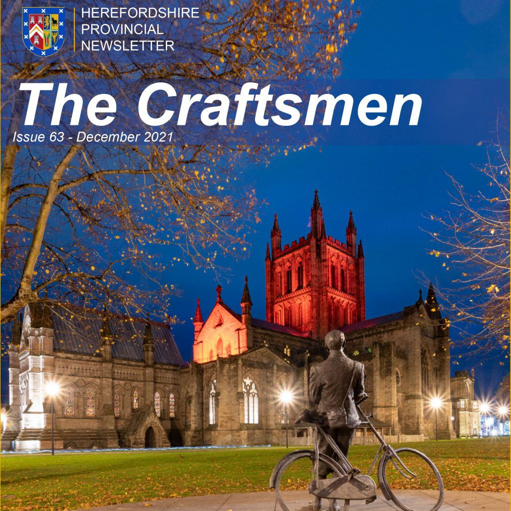 Front cover of the Craftsmen Elgar leaning on his bike looking at the cathedral bathed in red light.